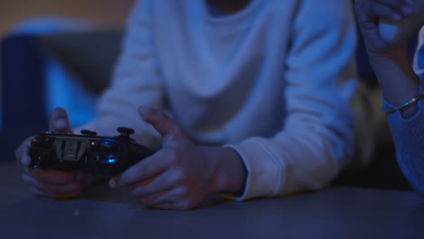 Close-Up-Of-Two-Young-Boys-At-Home-Playing-With-Computer-Games-Console-On-TV-Holding-Controllers-Late-At-Night-4